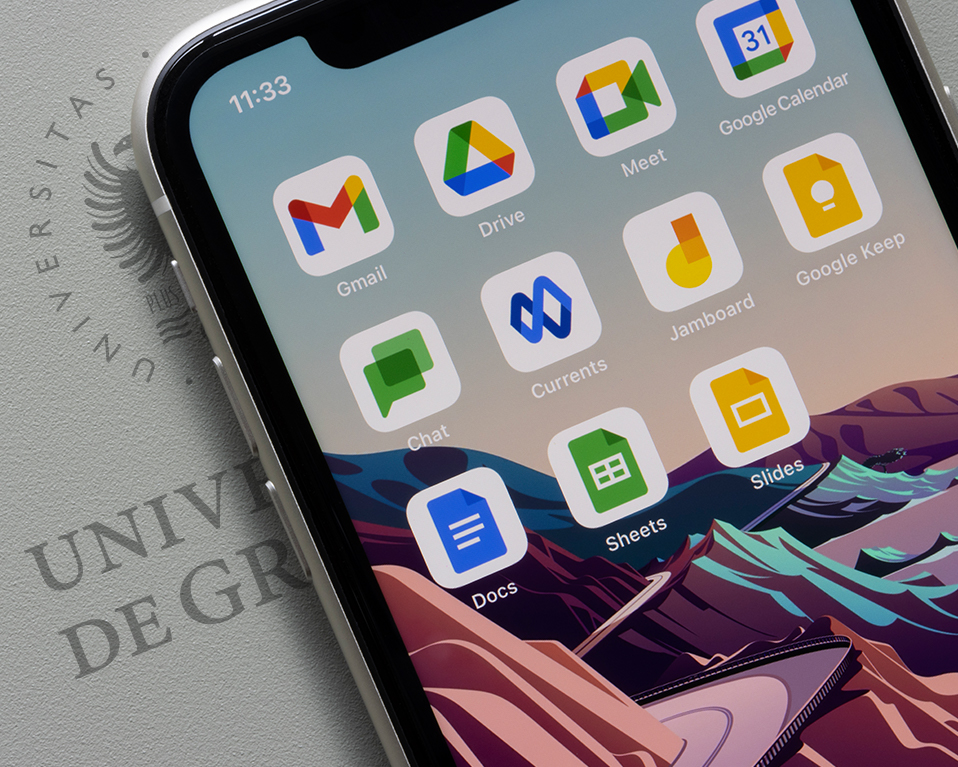 Imagen decorativa móvil con aplicaciones Google sobre folio con escudo UGR