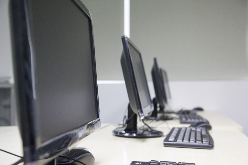 Imagen de tres pantallas de ordenador con sus teclados